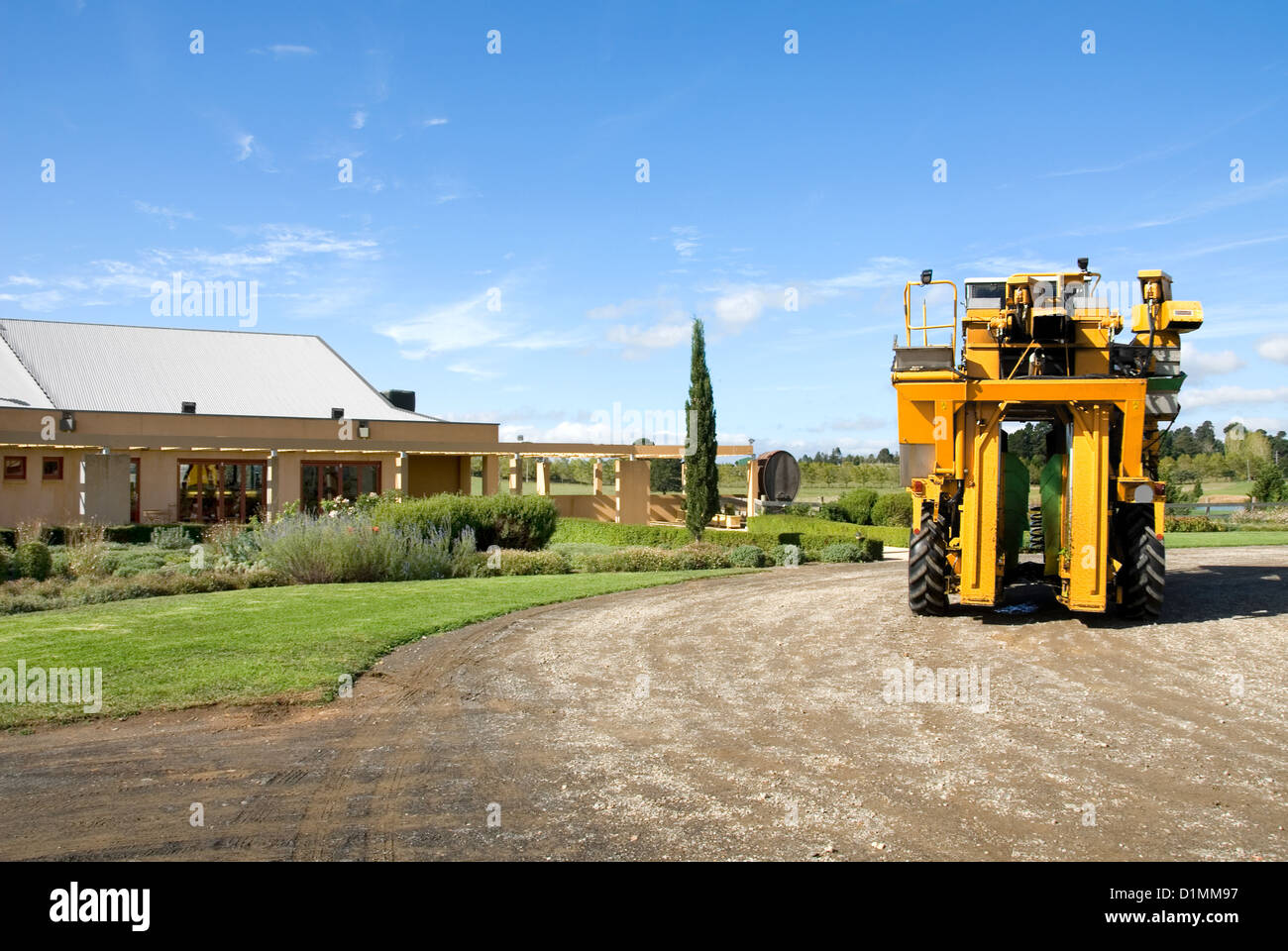 A grape harvester parked in front of the cellar door of a vineyard Stock Photo