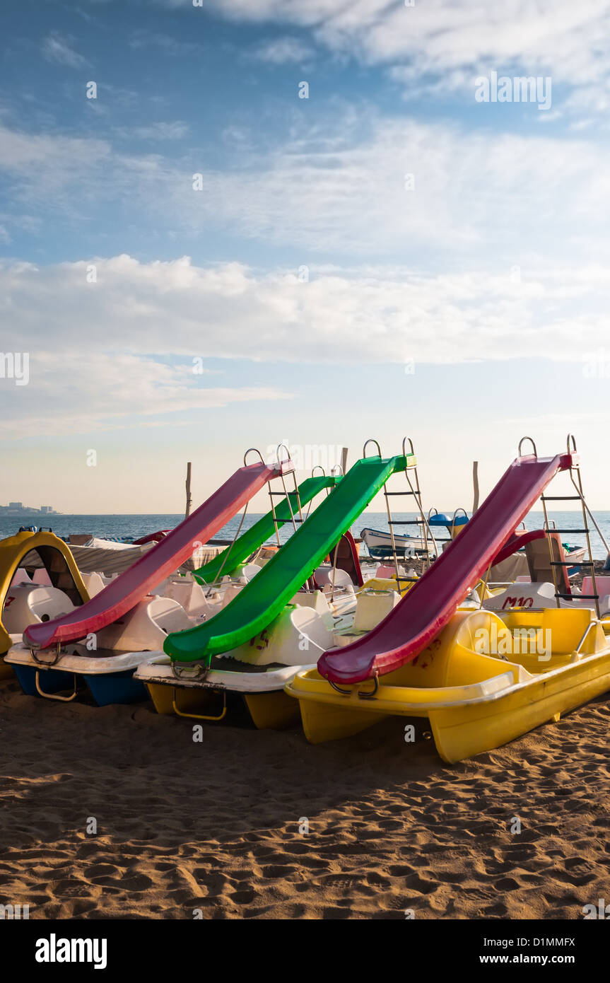Childrens slides parked on the beach waiting for the season Stock Photo