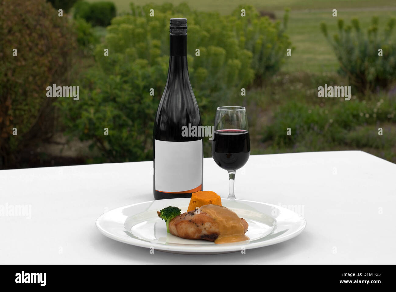 Pork Loin, served with a Roasted Pumpkin Timbale and Piquant Honey Sauce, accompanied by a glass of Merlot Stock Photo