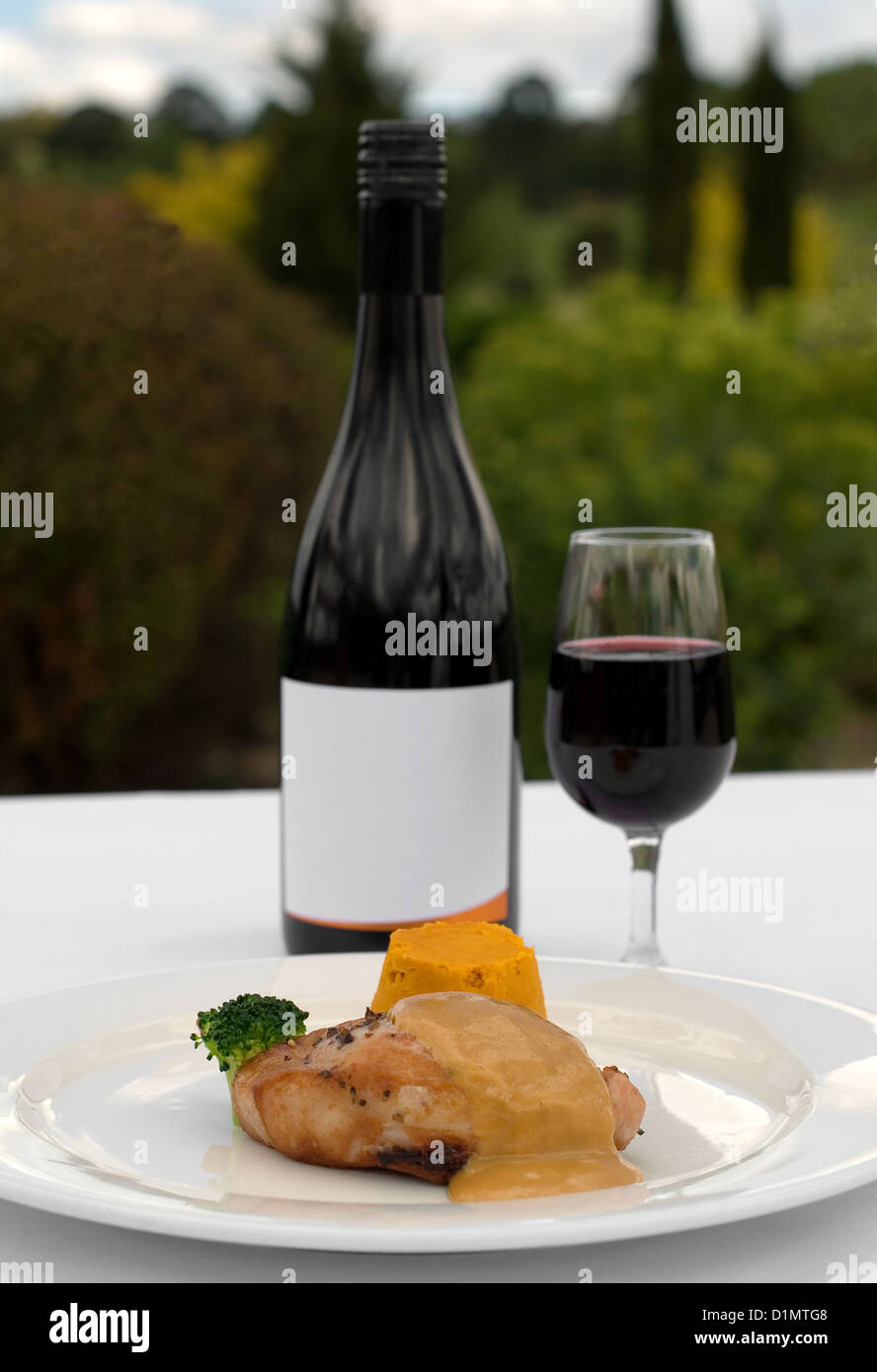 Pork Loin, served with a Roasted Pumpkin Timbale and Piquant Honey Sauce, accompanied by a glass of Merlot Stock Photo
