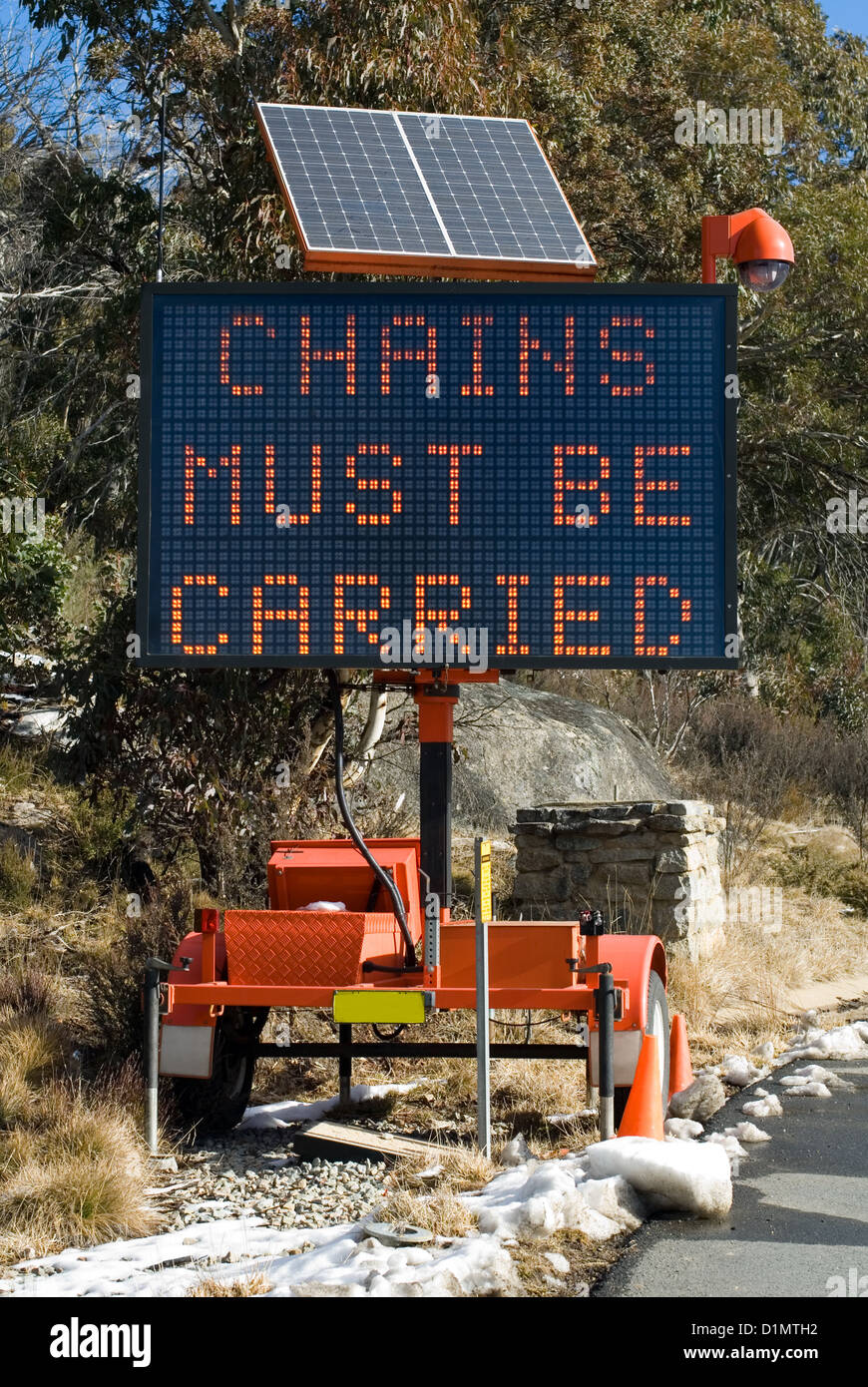 A portable electronic road sign programmed with a message warning that snow chains must be carried Stock Photo