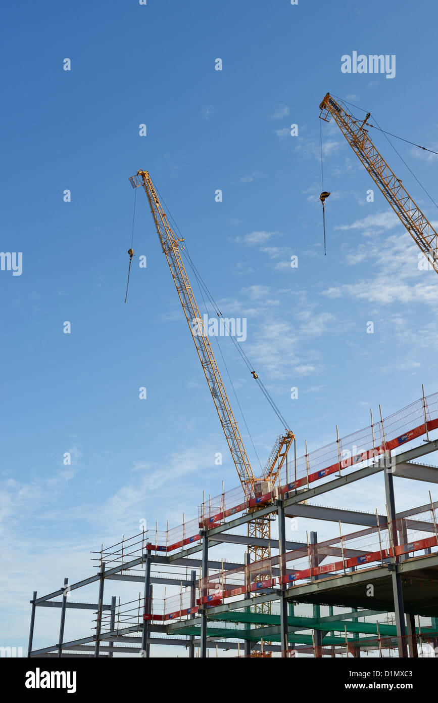 Steel frame and two cranes on a UK construction site Stock Photo