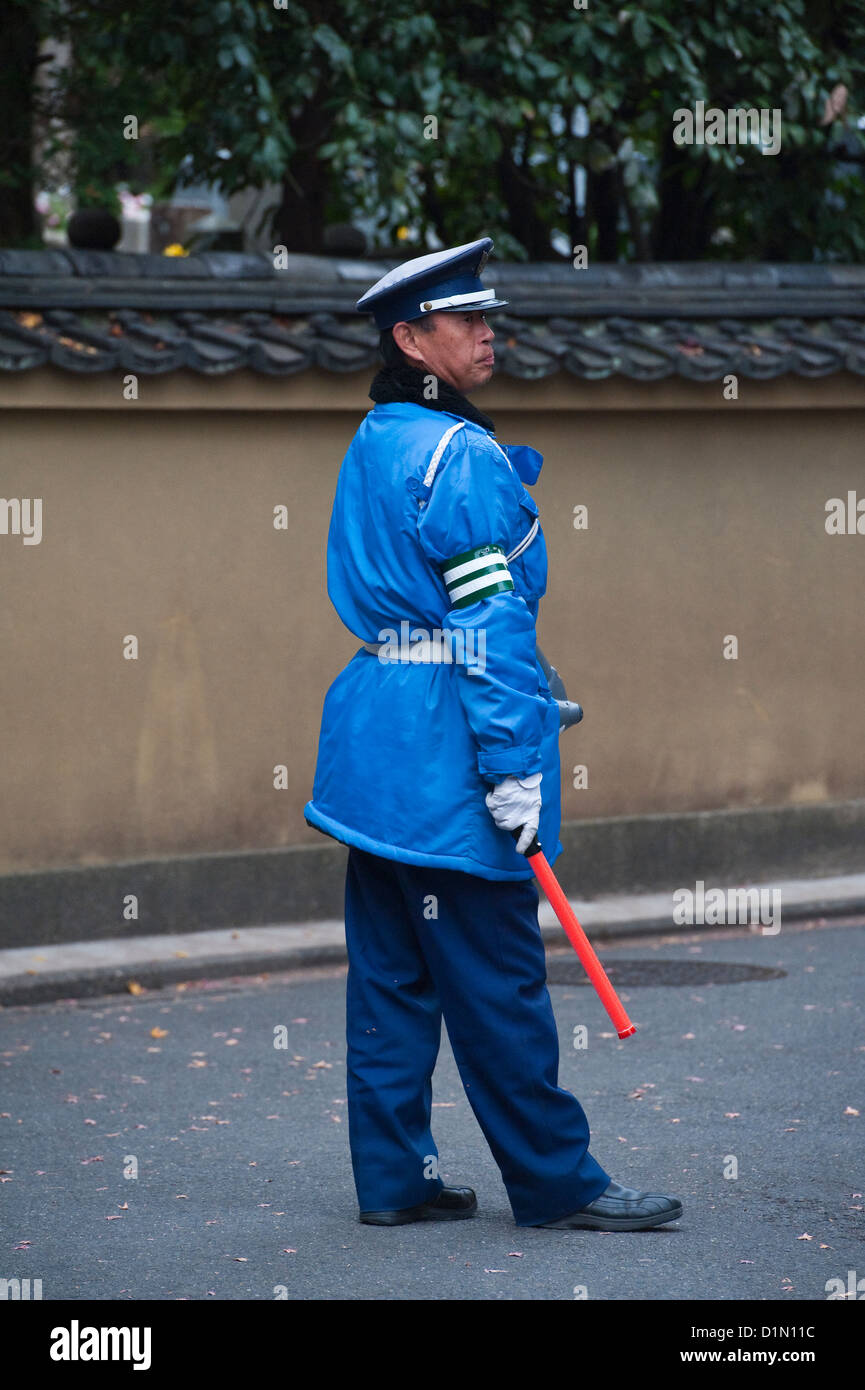 A security guard directing the huge crowds of tourists coming to view