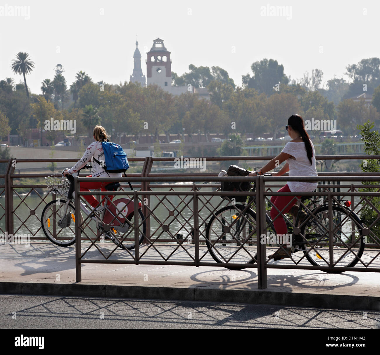 Two Young women riding on cycleway Cruzcampo Community hire bike in
