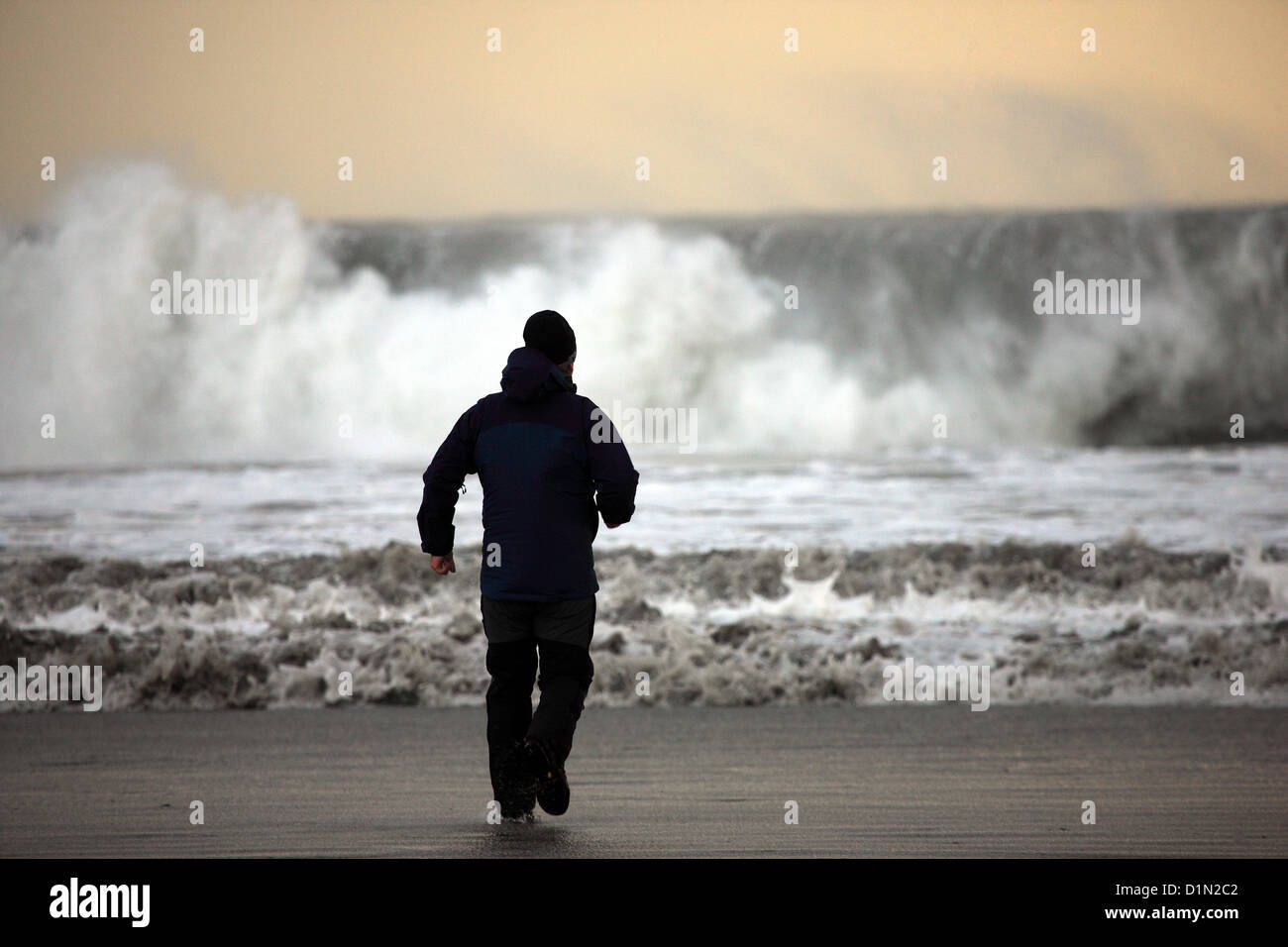 Isle of Mull, UK. Sunday 30 December 2012 - Man watches huge waves pounding the coastline on the Isle of Mull in the west coast of Scotland as winds gusting in excess of 50 miles per hour reach land Stock Photo