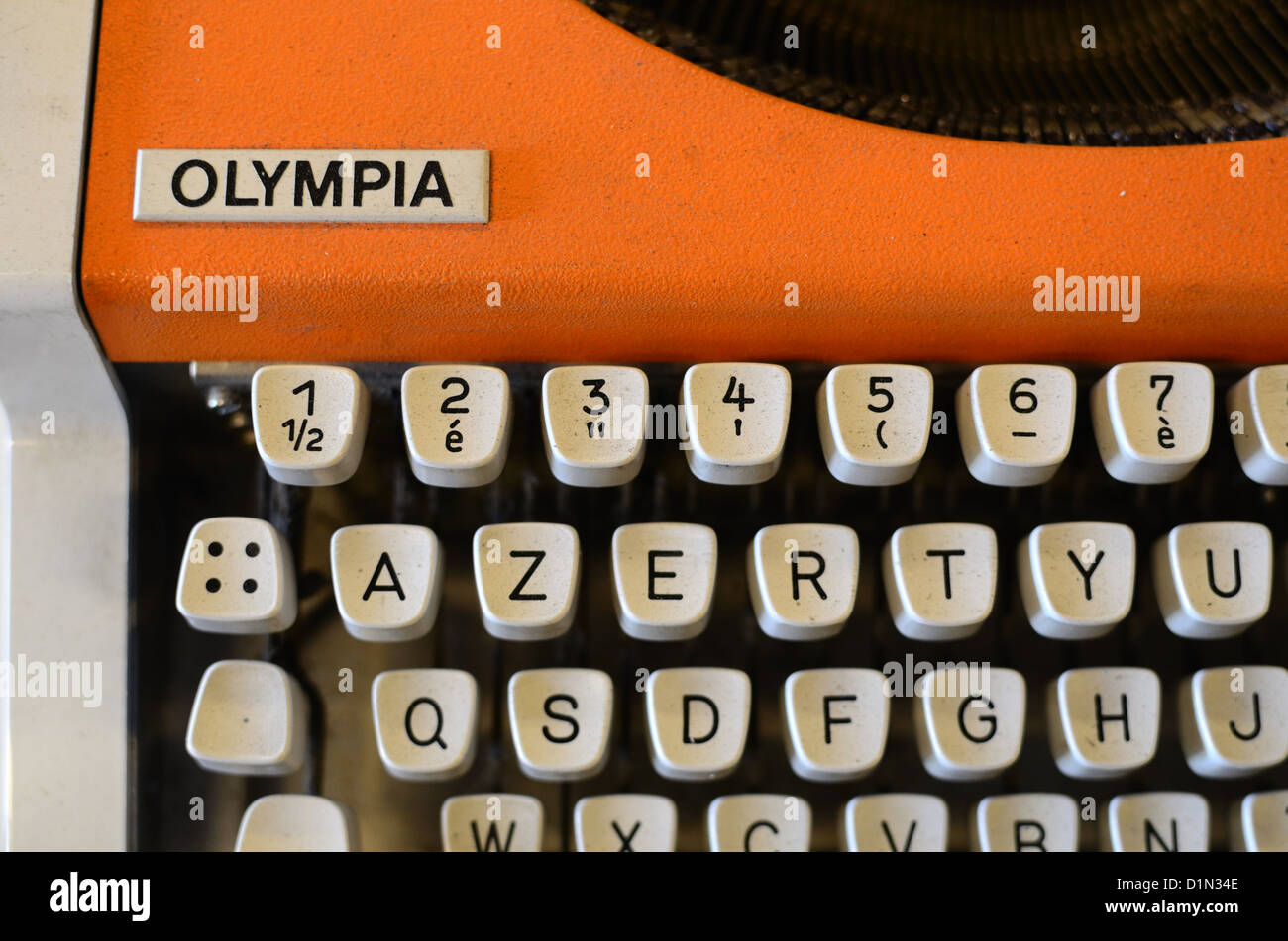 Old, Vintage, Retro or Antique Orange Olympia Typewriter with AZERTY Keyboard Stock Photo