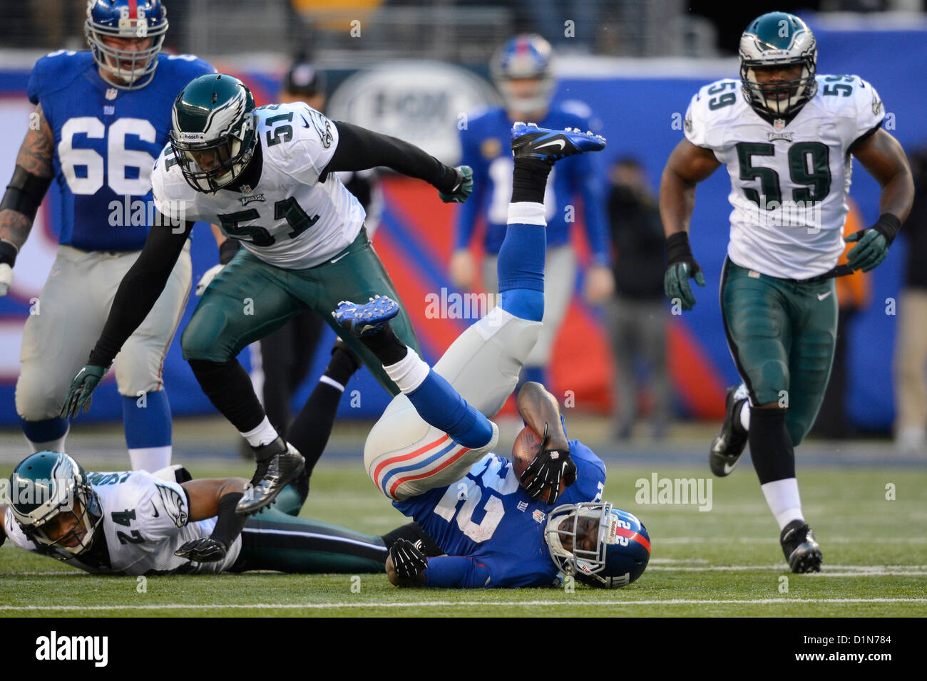 New Jersey, USA. 30 December 2012: New York Giants running back David Wilson (22) runs with the ball into Philadelphia Eagles cornerback Nnamdi Asomugha (24) and Philadelphia Eagles outside linebacker Jamar Chaney (51) during a week 17 NFL matchup between the Philadelphia Eagles and New York Giants at MetLife Stadium in East Rutherford, New Jersey. The Giants defeated the Eagles 42-7. Stock Photo