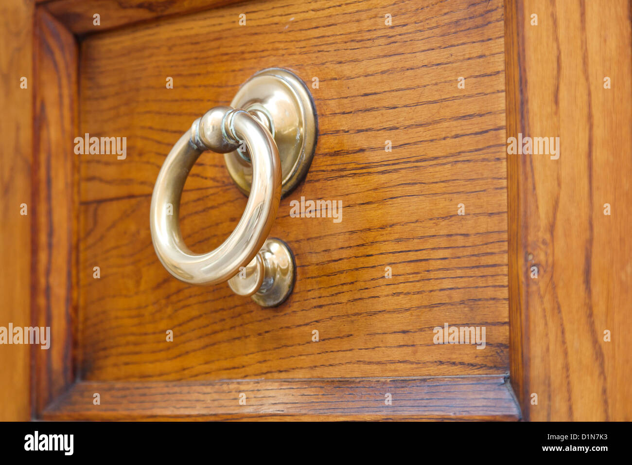 old brass ring door handle on wooden urban door Stock Photo