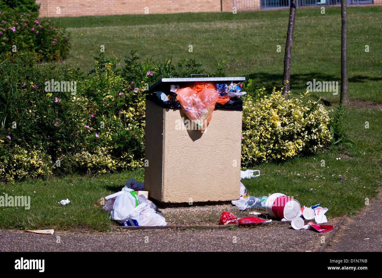 Rubbish overflowing in a bin in a park Stock Photo