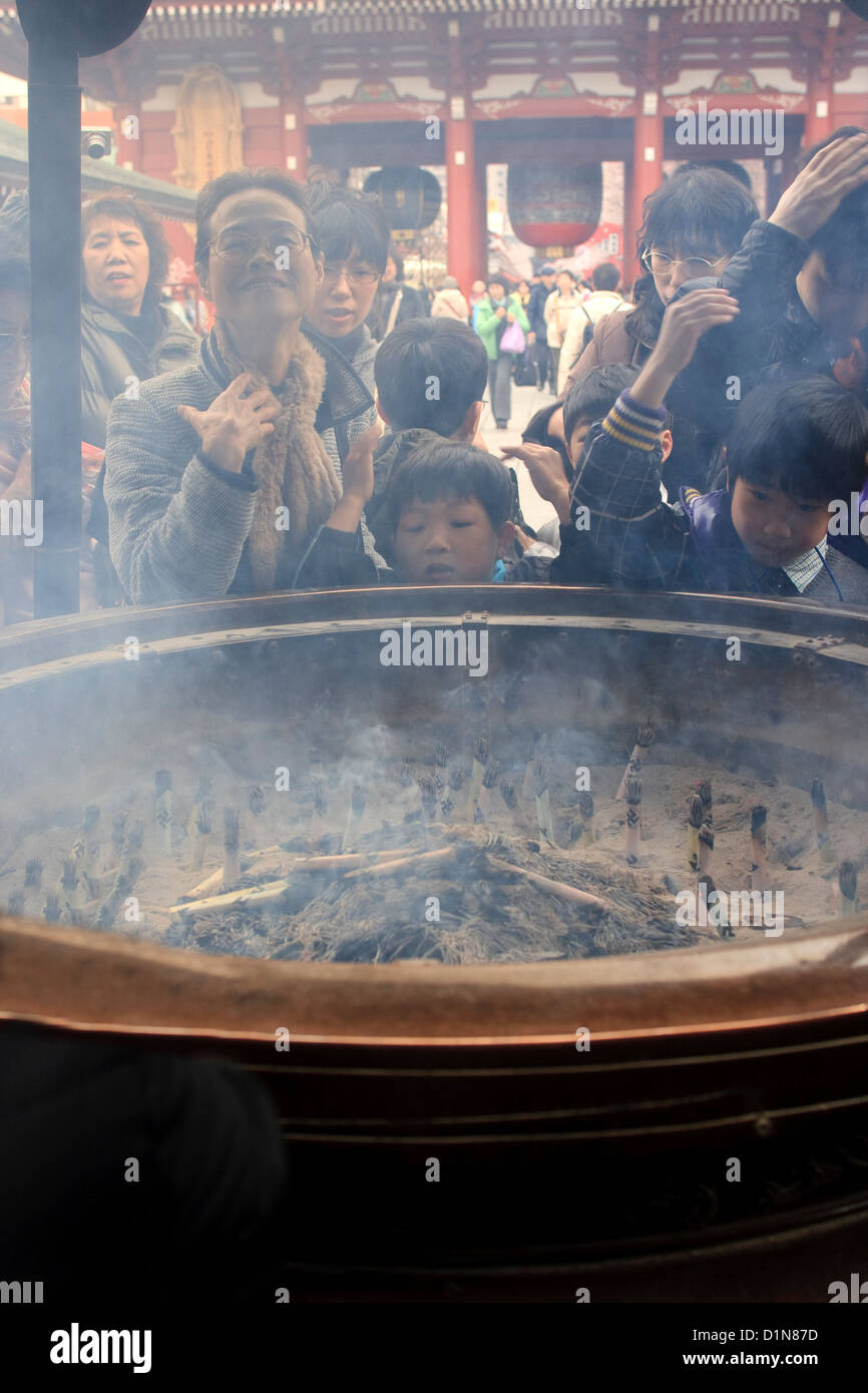 Inhaling incense smoke in Tokyo Stock Photo Alamy