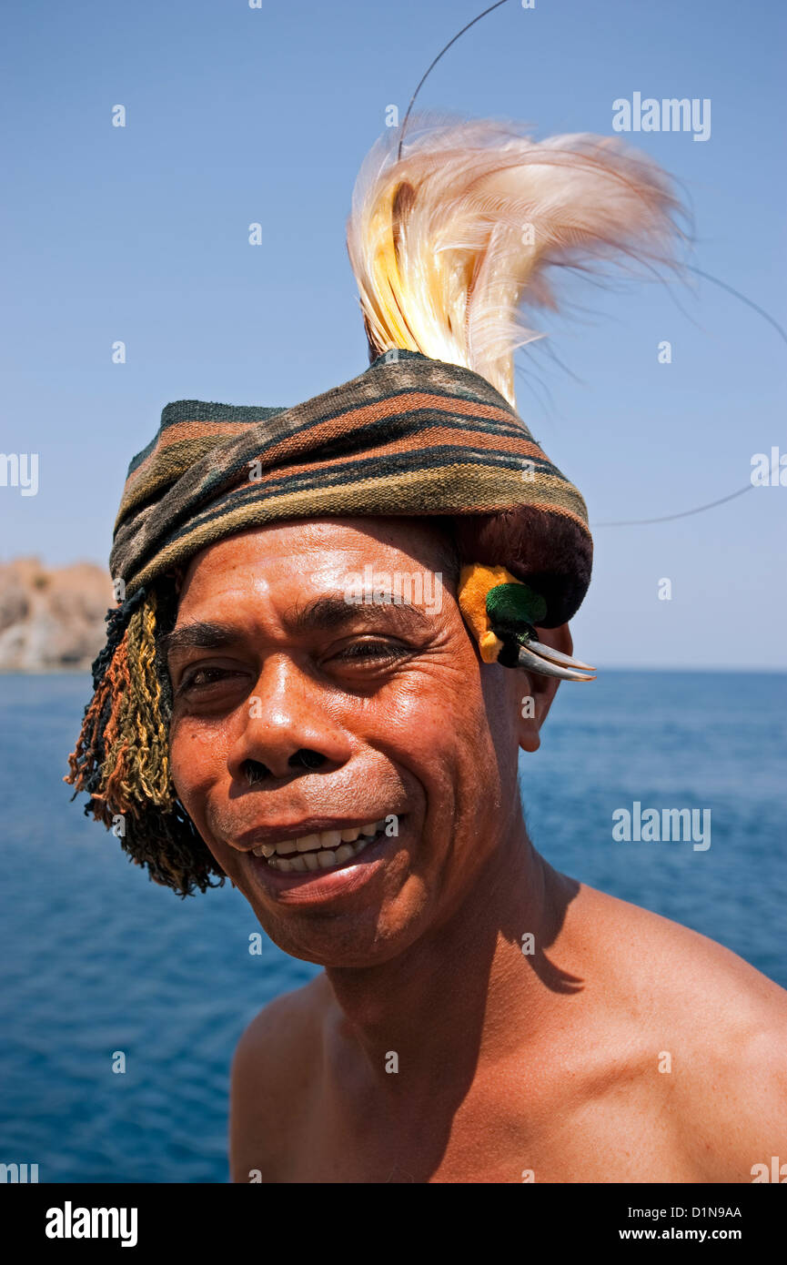 Indonesian man with great birds of paradise skin on his head as an ornament, Komodo Indonesia Stock Photo