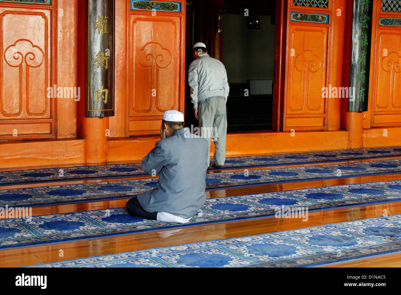 two chinese hui men pray at Xining's Great Mosque in their daily routine. it serves its resident Hui Muslim community china Stock Photo