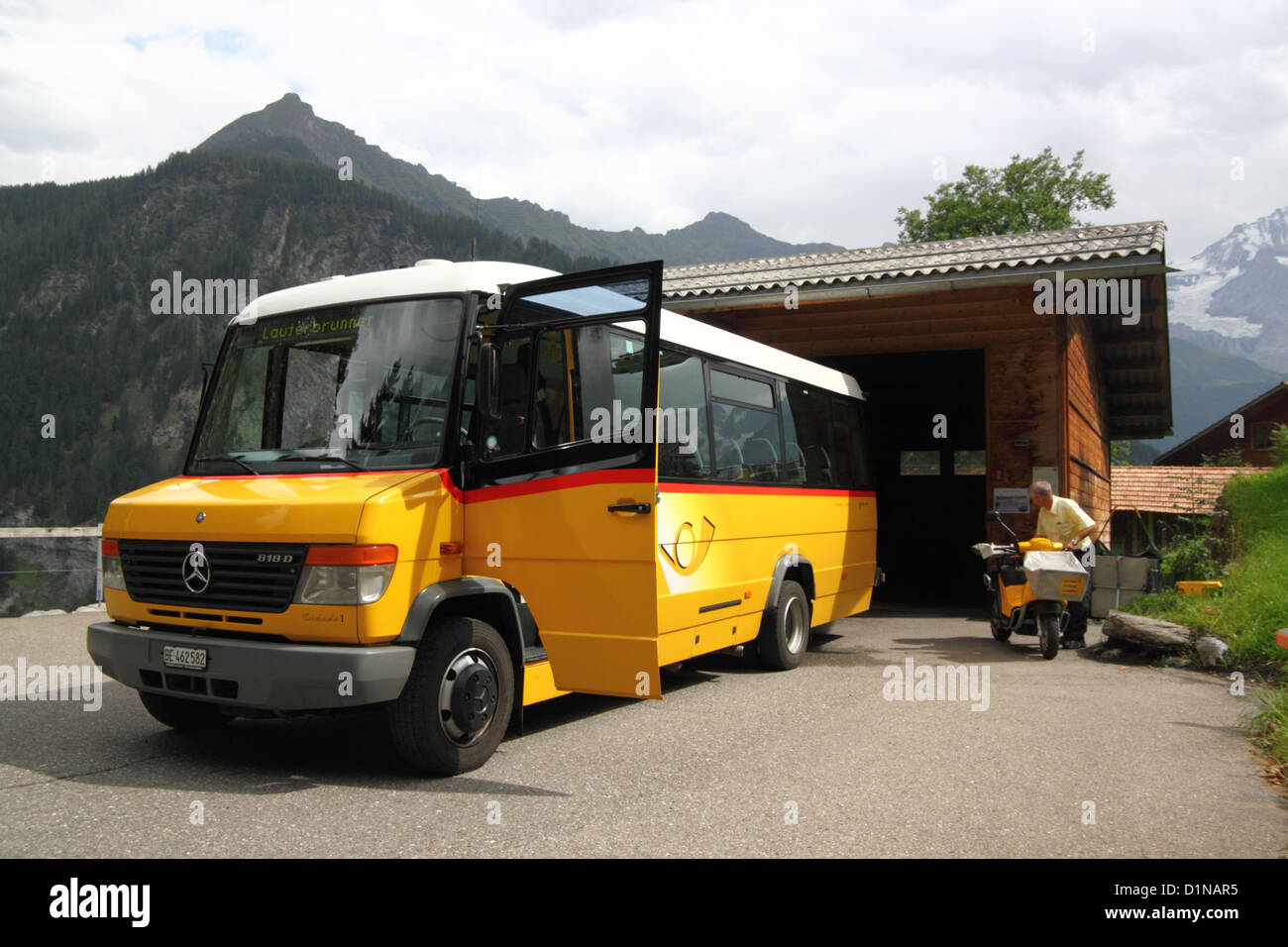 A Swiss postman changes from postbus to postbike at Isenfluh. Stock Photo
