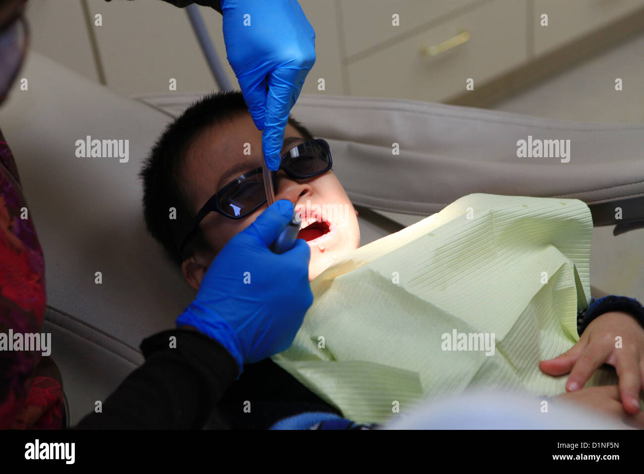 Dental nurse performing fluoride therapy on toddler boy patient Stock Photo Alamy