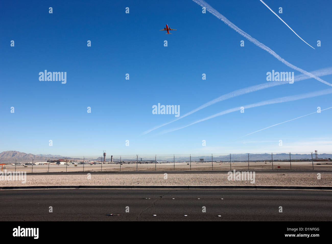 plane taking off into blue sky with contrails at the end of the runway at mccarran international airport Las Vegas Nevada USA Stock Photo