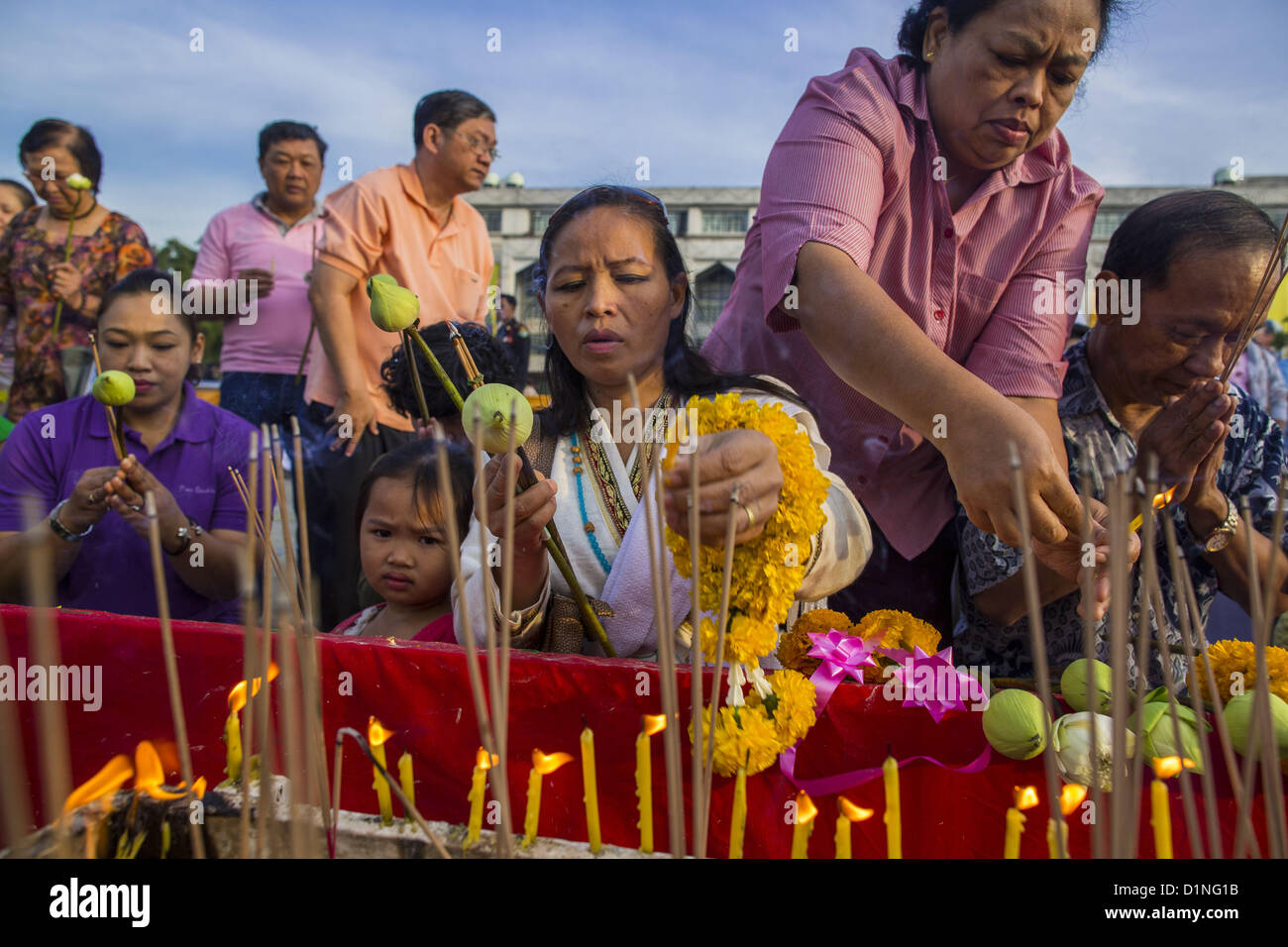 Jan. 1, 2013 - Bangkok, Thailand - People light candles and pray at a shrine during a special merit making ceremony at Bangkok City Hall New Year's morning. Many Thais go to Buddhist temples and shrines to ''make merit'' for the New Year. The traditional Thai New Year is based on the lunar calender and is celebrated in April, but the Gregorian New Year is celebrated throughout the Kingdom. (Credit Image: © Jack Kurtz/ZUMAPRESS.com) Stock Photo