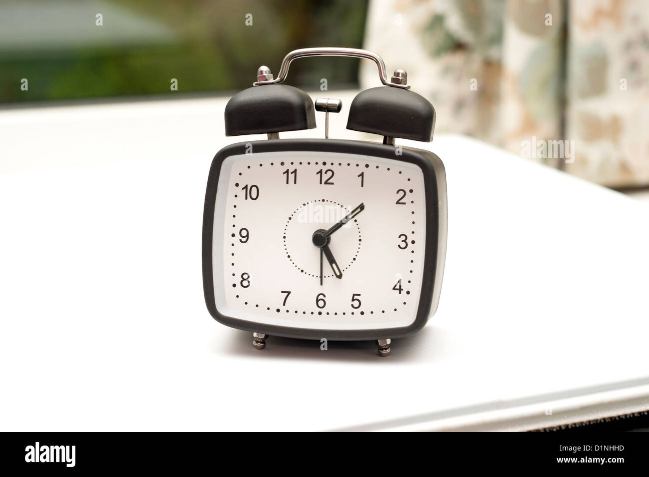 An alarm clock on a bedside table Stock Photo Alamy