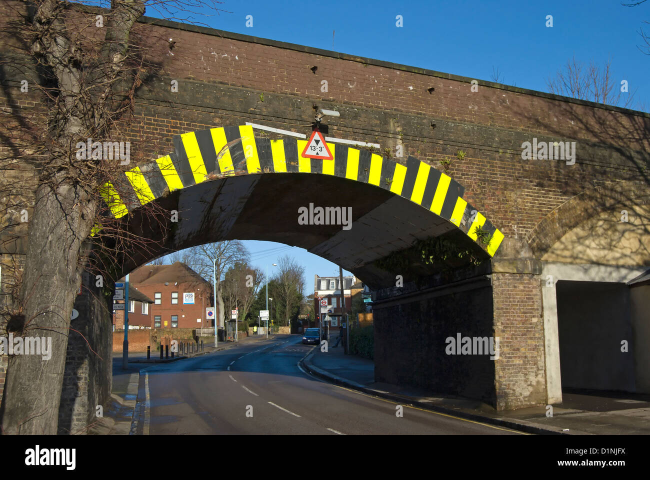 low bridge with height sign and hazard warning markings, isleworth, middlesex, england Stock Photo