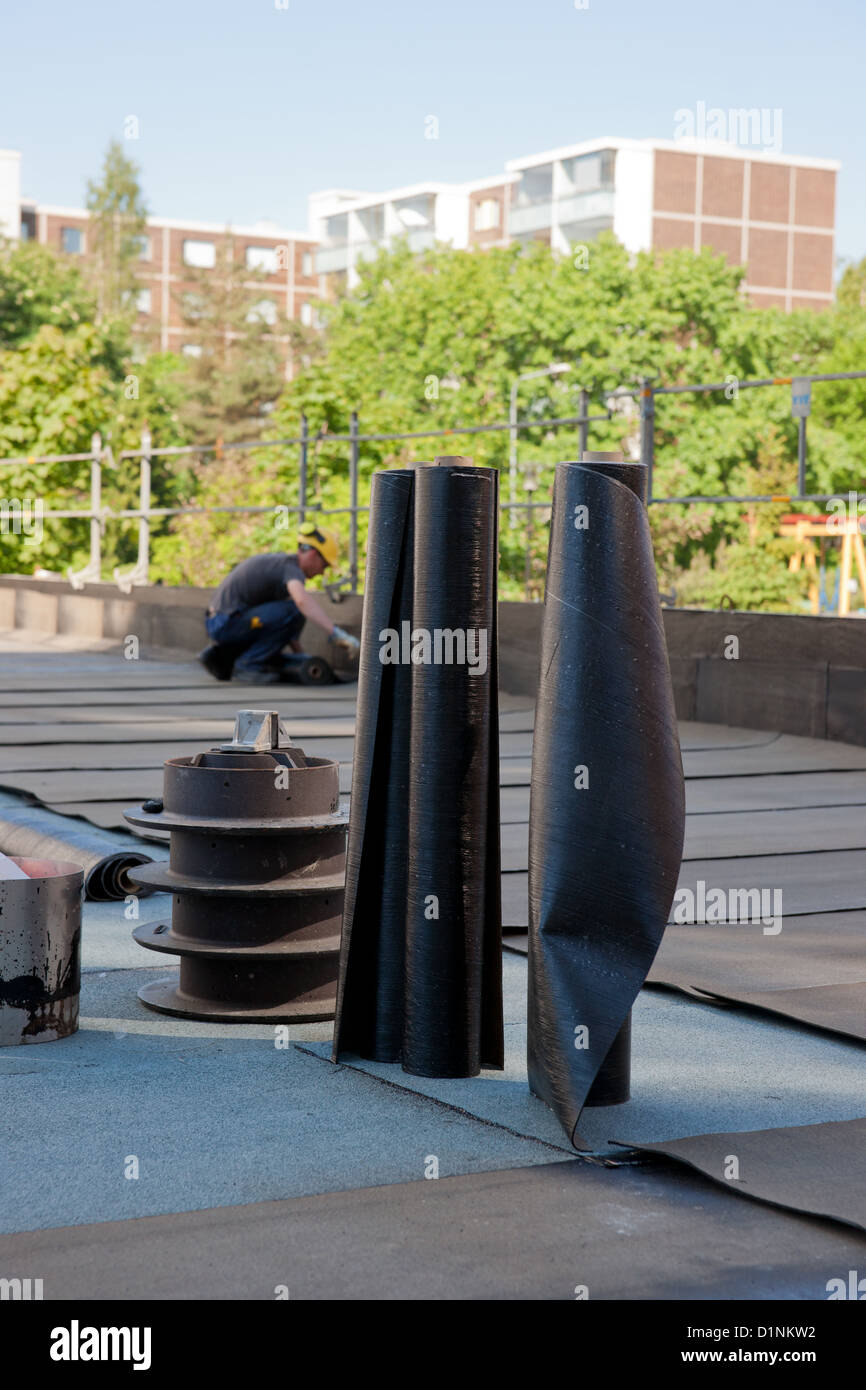 Bituminous roofing applying bitumen roll on a flat roof builder hires