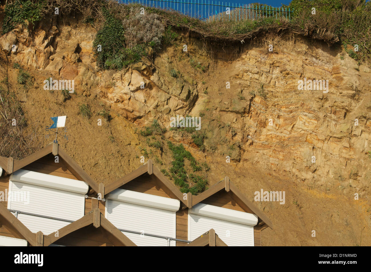 Swanage cliff overhang by beach huts at the northern end of Swanage bay Stock Photo