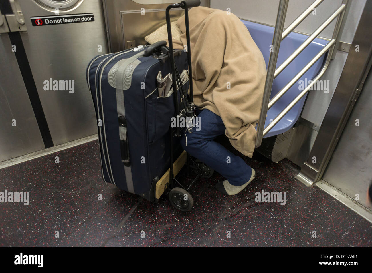 Homeless man escapes the cold and sleeps in a subway car in New York ...