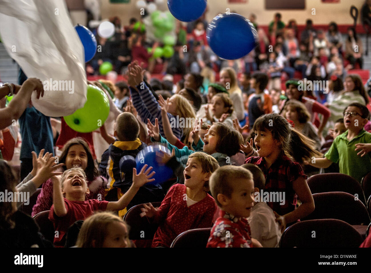 The audience at a Christmas pageant at the California School for the Deaf in Riverside, CA, happily plays with balloons. Stock Photo