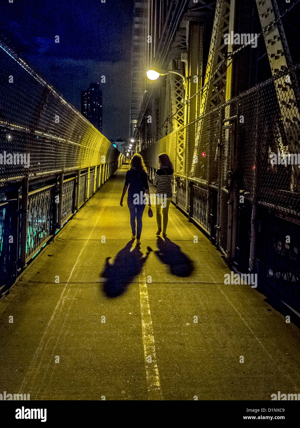 Two young women walk across New York City's Manhattan Bridge at night Stock  Photo - Alamy