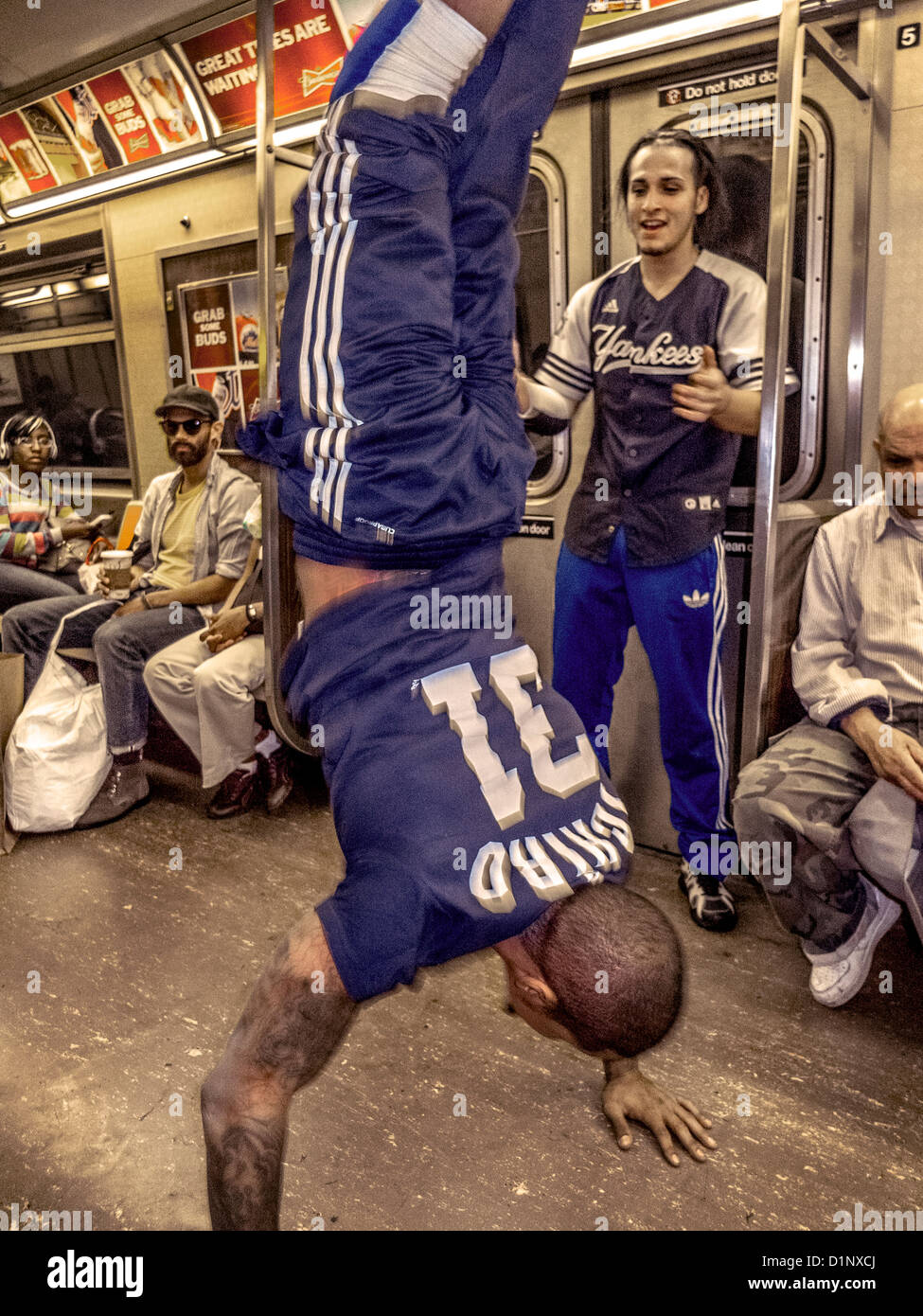 An African American man dances for passengers tips while riding in the New York City subway. Note partner. Stock Photo