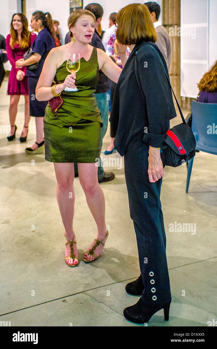 Fashionably dressed women talk at an art museum exhibition opening night and reception in Newport Beach, CA. Stock Photo