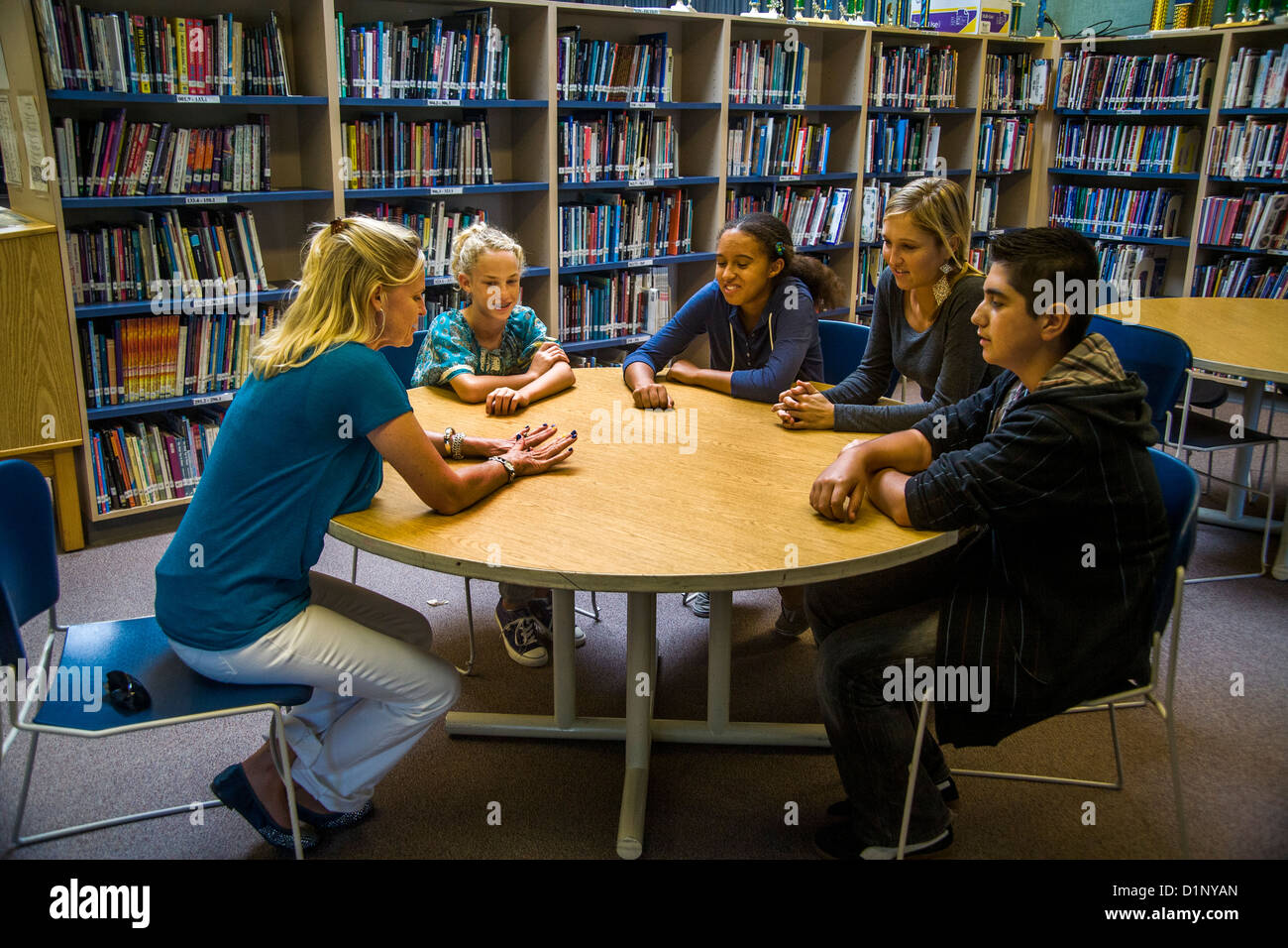 A junior high school counselor meets with a multiethnic group of students in a San Clemente, CA, school library. Stock Photo