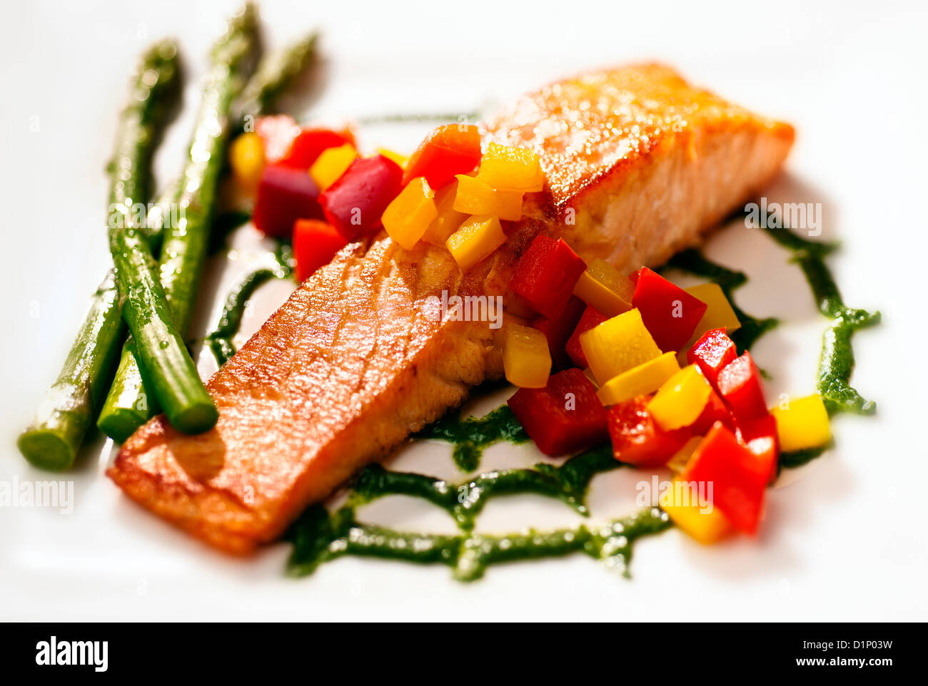 Pan-Seared Salmon with Watercress Puree, red & yellow peppers and asparagus on white plate Stock Photo