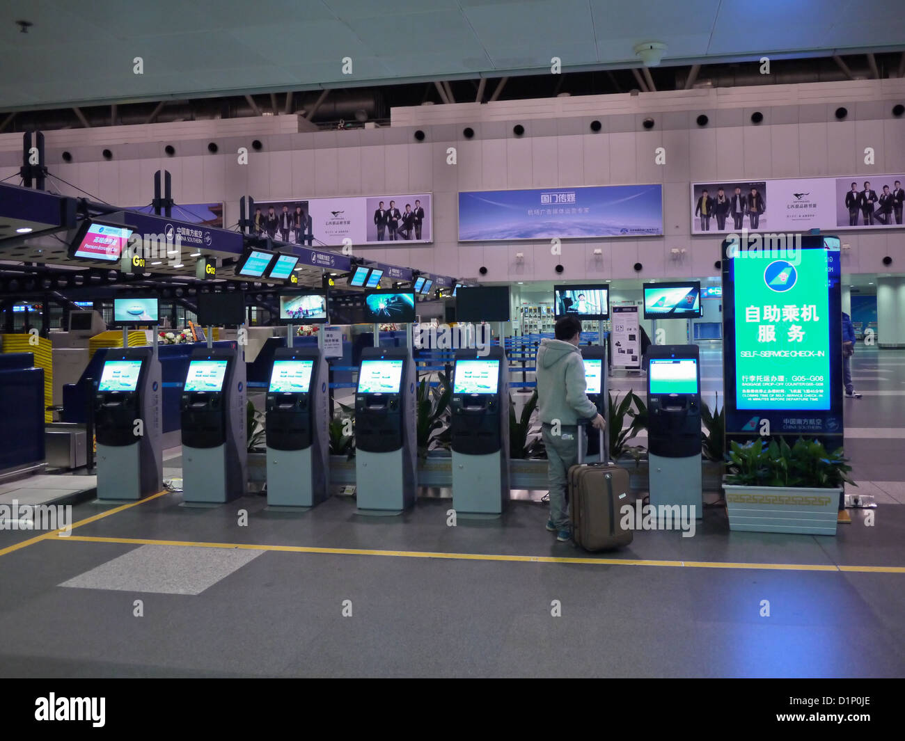 Singapore - Jun 27, 2017 : Flights Information Board And Machine At Changi  Airport Terminal 3.Young Girl With Her Mother Touching Self Check In Kiosks  Interactive Screen To Check In Online. Stock