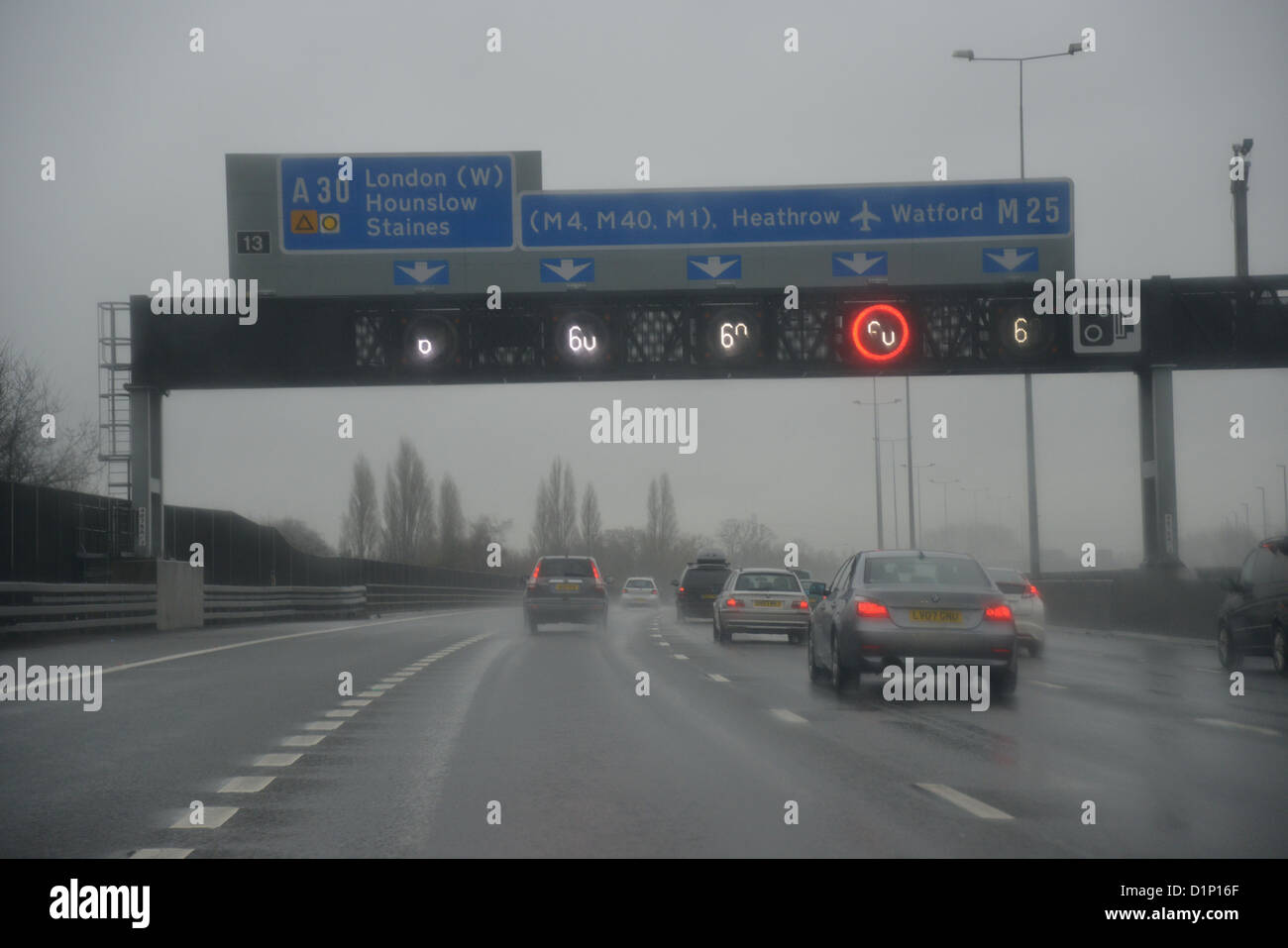 Speed restrictions in heavy rain on M25 Motorway, Surrey, England, United Kingdom Stock Photo
