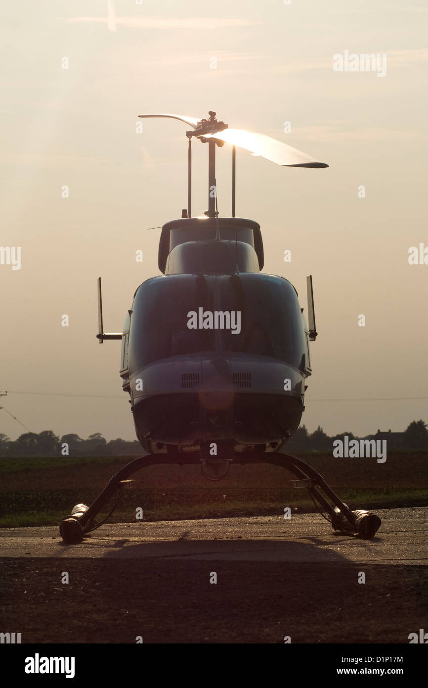 Grounded Helicopter reflecting the falling sun Stock Photo