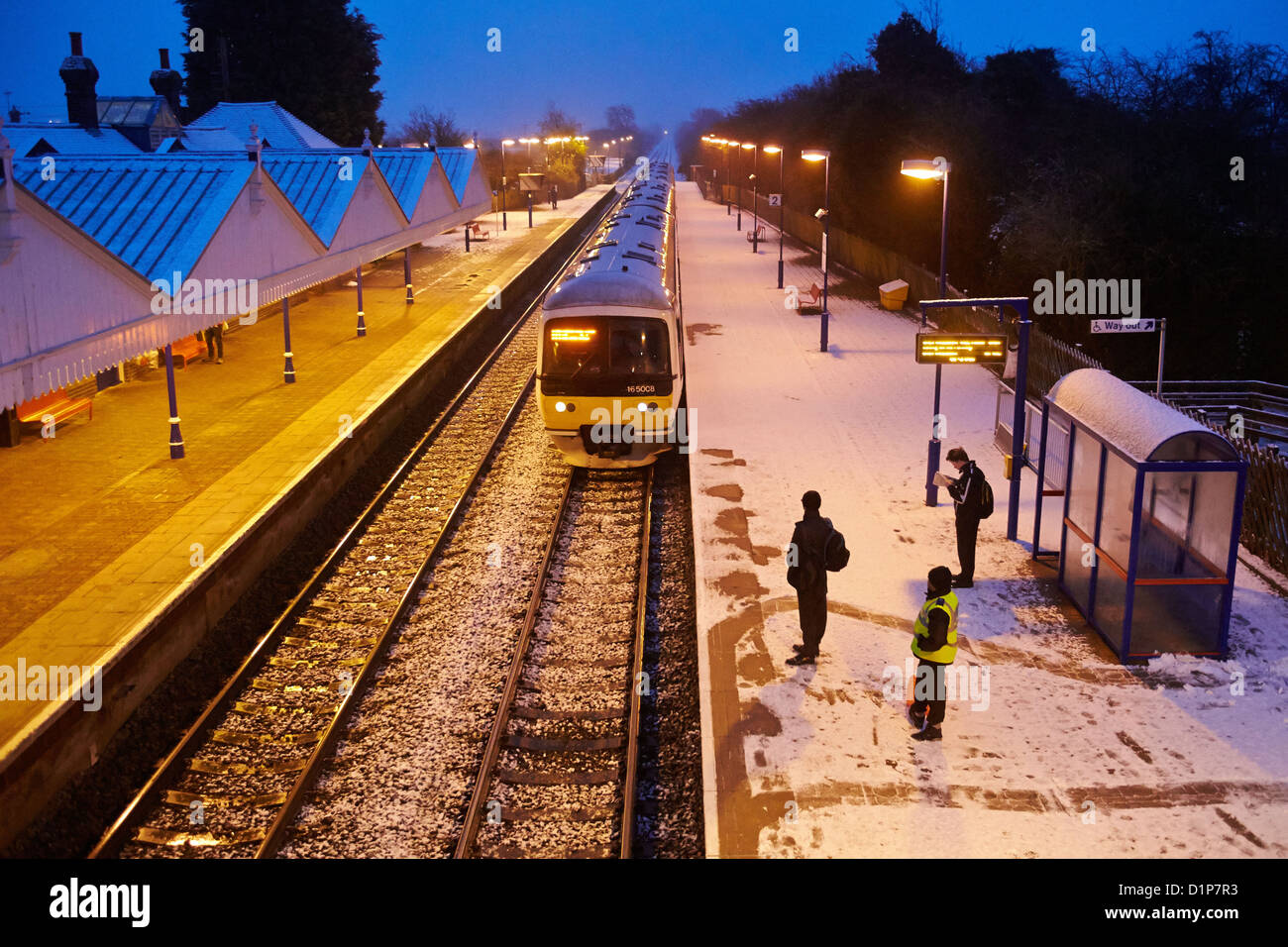 Commuters wait in the snow for a train at Stoke Mandeville station Stock Photo