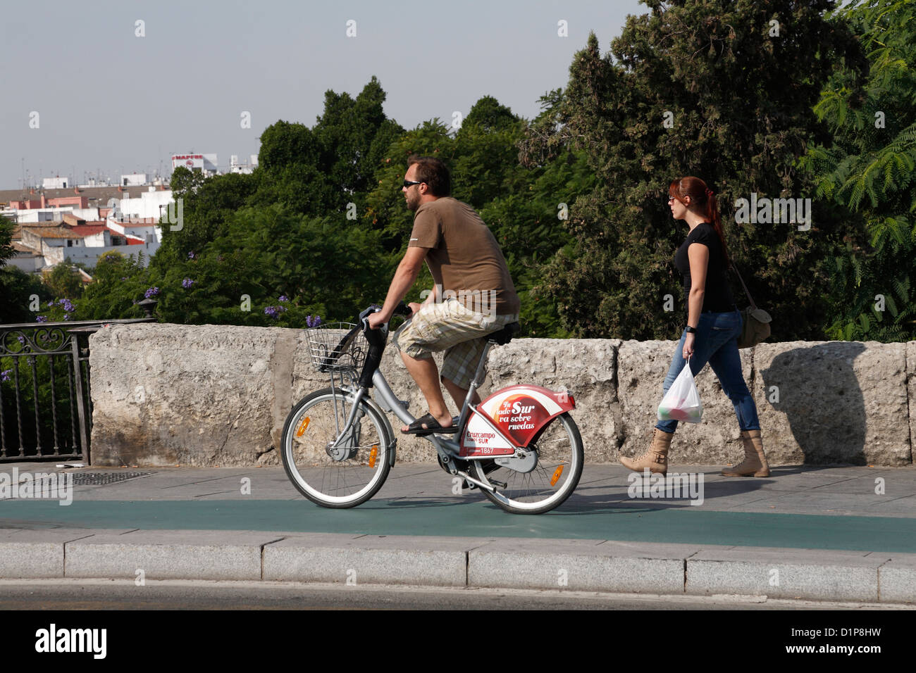 woman girl walking Young man riding Community hire bikes Espana in