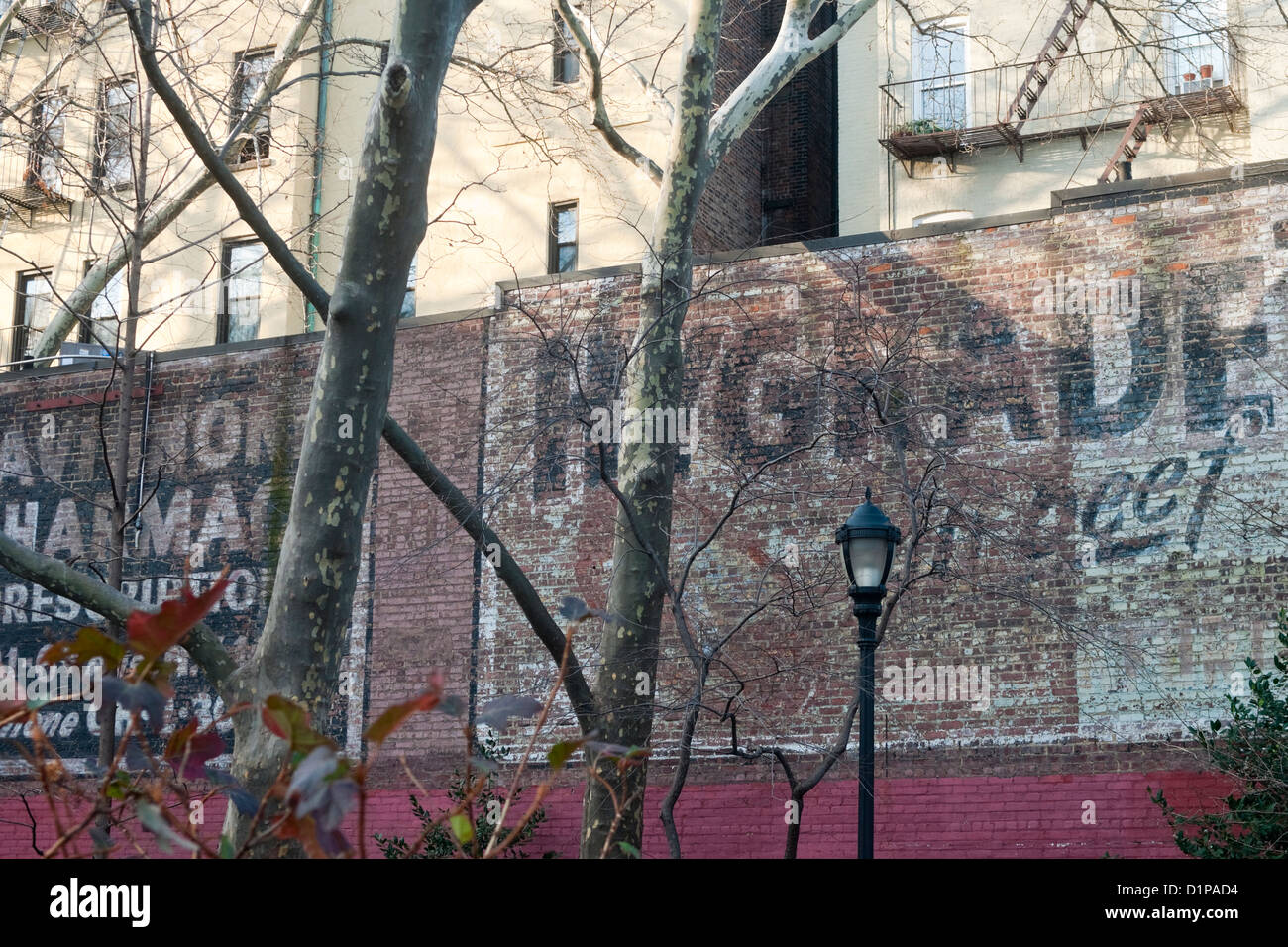 New York, NY - Old faded billboard advertising for Hygrade and Avignone Pharmacy on a brick wall at Winston Churchill Square. Stock Photo