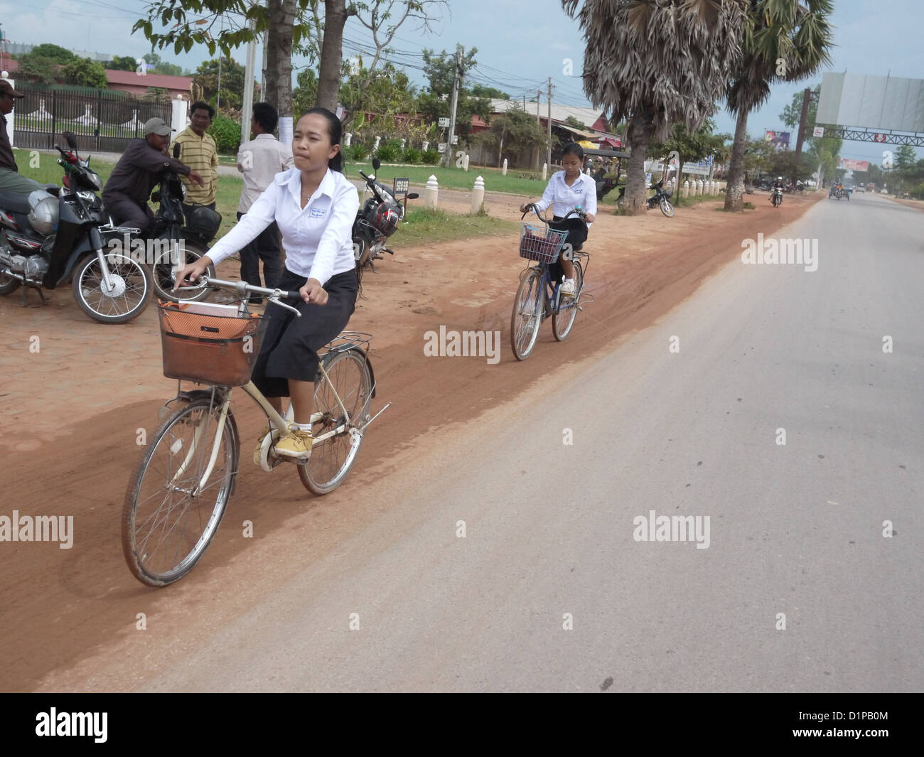 young girl riding bicycle to school Cambodia Stock Photo