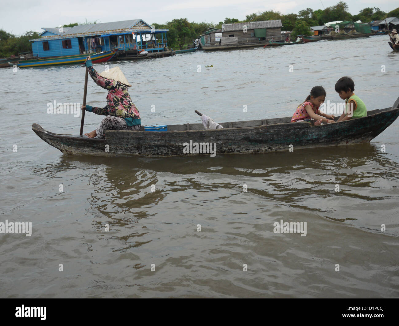 Asian woman steer boat young boy girl playing Stock Photo