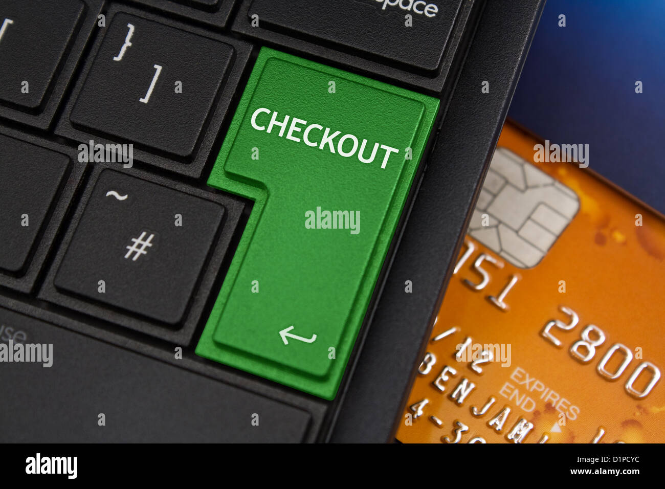 Checkout Enter Key on a modern laptop qwerty keyboard with bank smart card underneath to represent online shopping Stock Photo