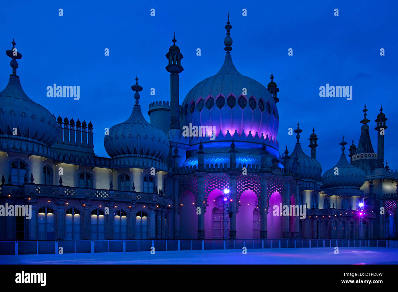 Brighton Royal Pavilion with winter ice skating rink and skaters at night, Brighton, East Sussex, England Stock Photo