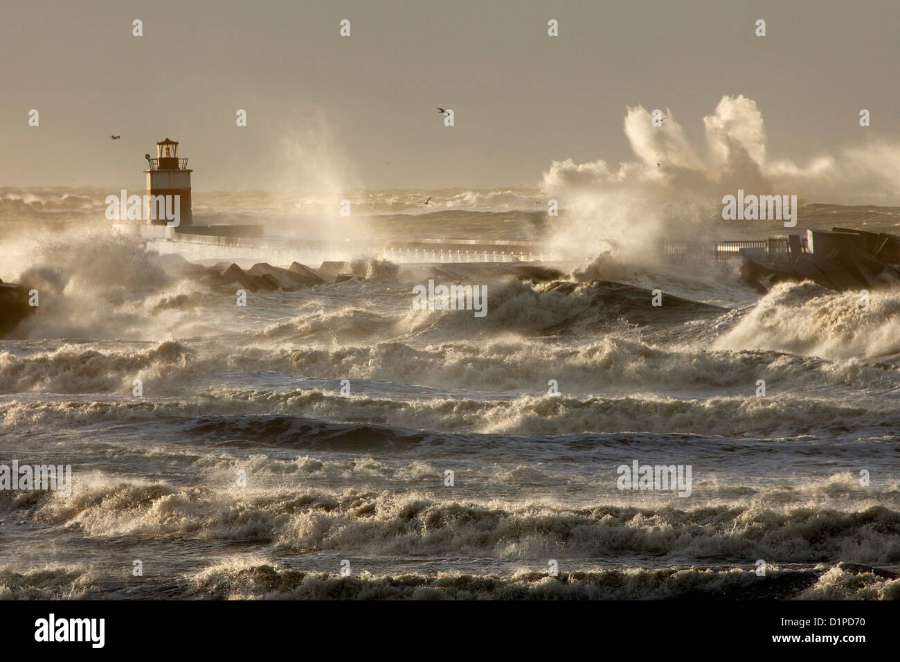 The Netherlands, IJmuiden, Storm. Waves crash against lighthouse or beacon. Stock Photo