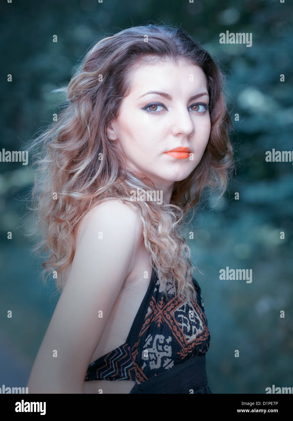 Portrait of a sad 20 year old woman looking at camera over shoulder. Stock Photo