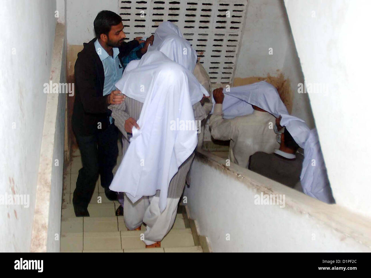 CID Police Officials escort arrest activists of defunct  organizations during targeted raids in different areas, to show media persons during press  conference at Garden Police Headquarter in Karachi on Wednesday, January 02, 2013. These  arrestees were in involved in sectarian target killing. CID officials recovered 02 Kalashnikov, 05  Hand Grenade, 11 Pistols, 02 Tripple-2 Riffles, 01 Repeater Riffles and different types of bullets. Stock Photo