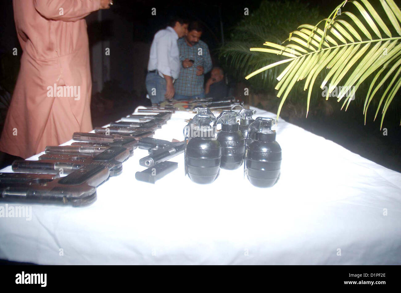 CID Police Officials show seized weapon to media persons  that recovered from activists of defunct organizations during targeted raids in different areas, at  Garden Police Headquarter in Karachi on Wednesday, January 02, 2013. These arrestees were in  involved in sectarian target killing. CID officials recovered 02 Kalashnikov, 05 Hand Grenade,  11 Pistols, 02 Tripple-2 Riffles, 01 Repeater Riffles and different types of bullets. Stock Photo