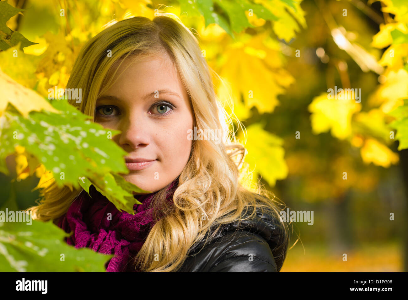Beautiful girl face poses on a park, autumn color leaves on the background, horizon format Stock Photo
