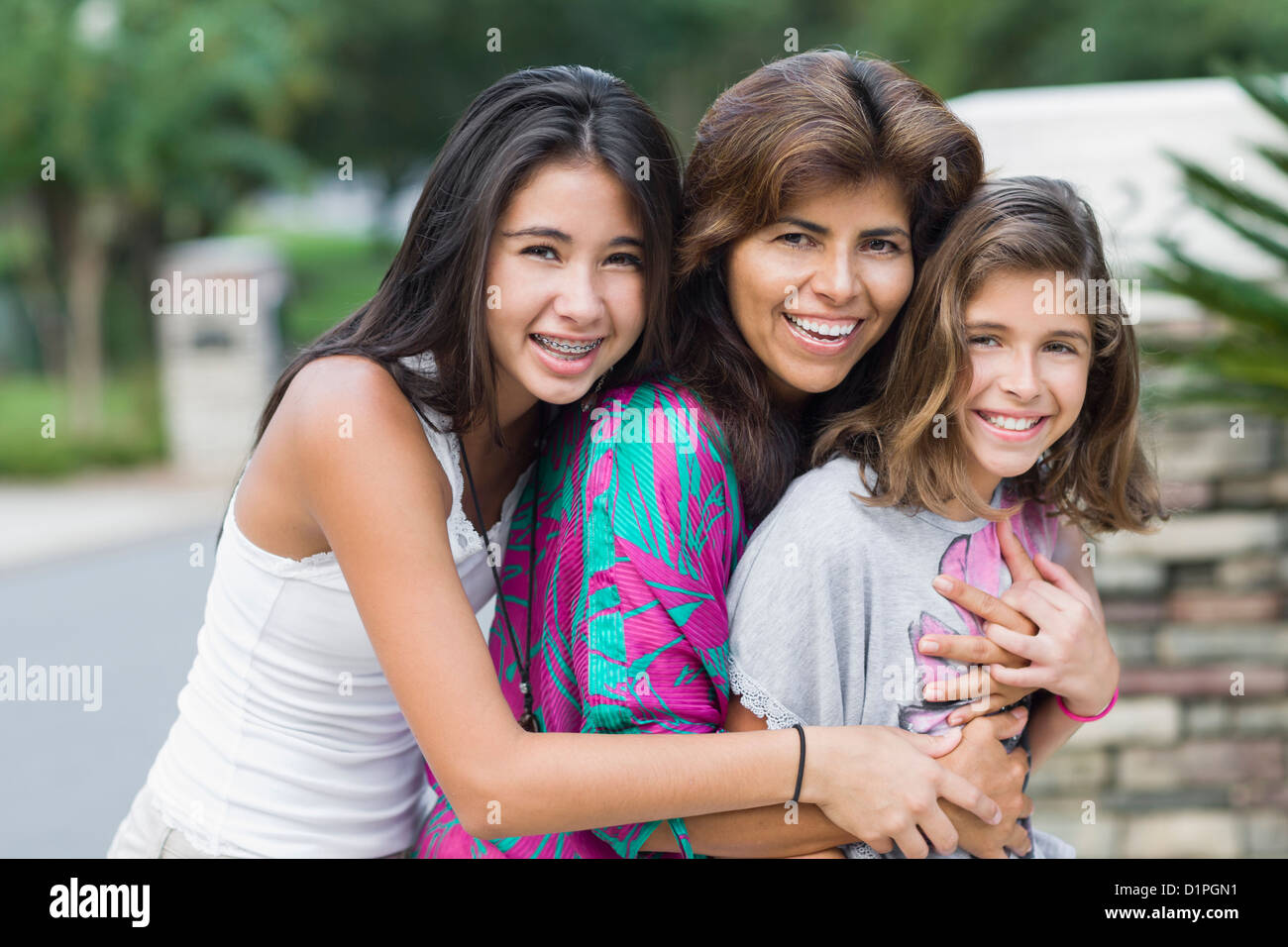 Smiling Hispanic mother and daughters Stock Photo