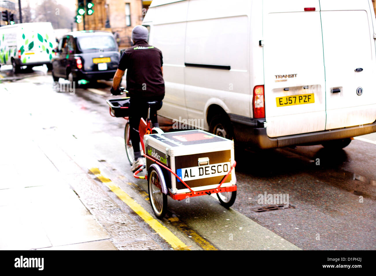 Bicycle sandwich delivery man on a street in central London, next to a white van Stock Photo