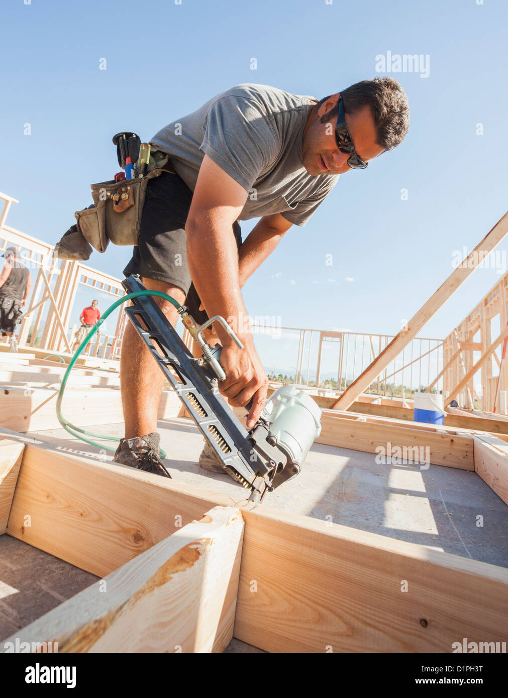 Caucasian man using nail gun on frame Stock Photo Alamy