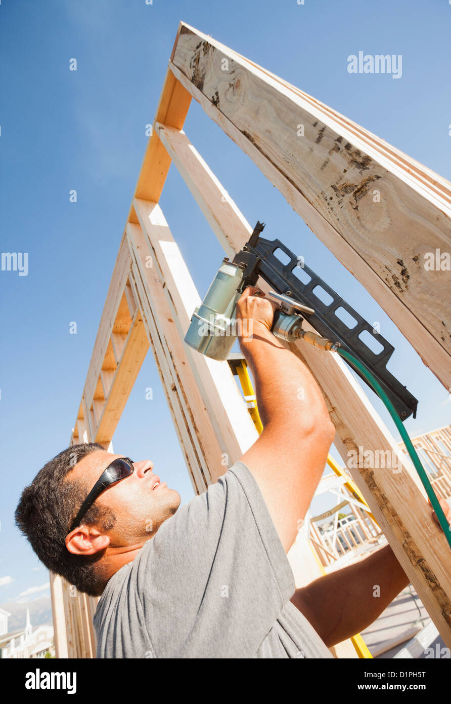 Caucasian man using nail gun on frame Stock Photo Alamy